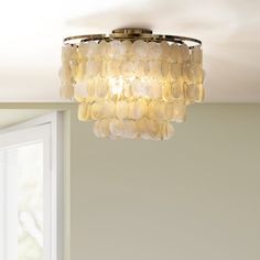 a chandelier hanging from the ceiling in a room with white walls and windows