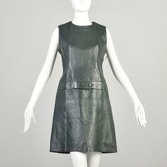 "A sleeveless shift made of dark green leather, so mod! This versatile mini can be worn as is or layered for a completely different look. Condition: Very Good Condition Details: There is slight dye fading discoloration in the lining of the underarms. Some of the edges of the leather like around the attached belt, underarms, and hem show slight signs of wear. The belt snaps have some patina on the underside but this is not noticeable when worn. This dress presents very sleek and classy.  Size Marked: 44 Approximate Size: Large **Please Check Measurements to be Sure! Textile: Unmarked, leather Lining Type: Fully Lined Closure: Back Zip, Hook & Eye  Label: Beged-Or Era: 1960s Measurements- Chest/Bust:  38\" Waist:  32\" Hips:  38\" Length from Collar to Hem:  36\" All measurements taken with Vegan Leather Shift Mini Dress, Green Leather Dress, Sleeveless Sleek Leather Mini Dress, Leather Shift Dress, Black Leather Sleeveless Mini Dress, Work Party Dress, Green Mod Cotton Dress, Casual Maxi Skirt, Red Dress Long