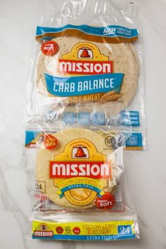 three bags of mission carb balance tortillas on a marble countertop in front of a white background