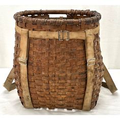 an old woven basket sitting on top of a white table