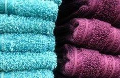 towels are stacked on top of each other in blue and pink colors, with one folded up to the side