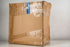 a large cardboard box sitting on top of a white table next to a gray wall