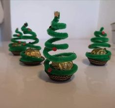 some green cupcakes with gold decorations on them and one has a christmas tree in the middle