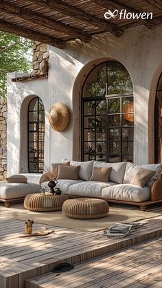 an outdoor living room with wooden flooring and white couches on the outside patio