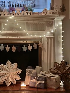 a fireplace decorated for christmas with presents and lights on the mantel above it is a snowflake