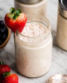 a strawberry yogurt overnight oats in a mason jar with strawberries on the side