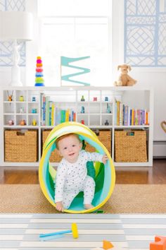 a baby is sitting in a play tunnel