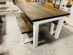 a table and bench made out of wood in a room with other items on the floor