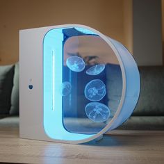 an electronic device with jellyfish in it sitting on a table next to a couch