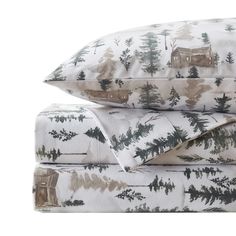 the bedding is made up with pine trees and houses on white sheets, along with matching pillow cases