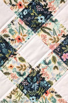 a close up view of a quilt with flowers on it