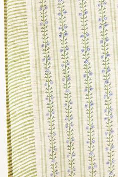 a green and white striped fabric with blue flowers on it