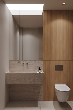 a bathroom with a toilet, sink and wooden paneling on the wall behind it