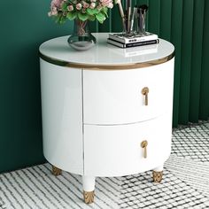 a white and gold sideboard with flowers on top in front of a green wall