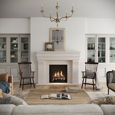 a living room filled with furniture and a fire place under a chandelier in front of a fireplace