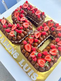 chocolate covered cake with strawberries in the shape of letter e on top of it