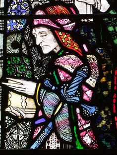 a stained glass window with a woman holding a bird in it's hand and another person standing next to her