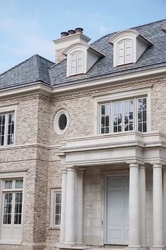 a large brick house with white columns and windows