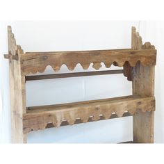 a wooden shelf with two shelves on each side and scalloped edges, against a white wall