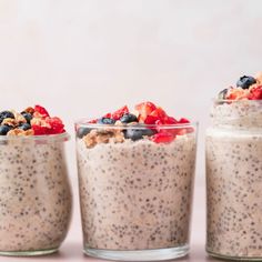 three glass jars filled with oatmeal and berries on top of each other