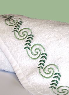 a white towel with green embroidered vines on it