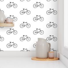 the wallpaper is decorated with black and white bicycles on it, along with two vases