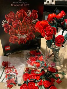 there are many red roses in the vases on the table next to each other