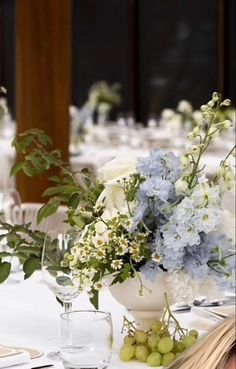 a vase filled with blue and white flowers sitting on top of a dining room table