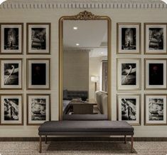 a bed sitting under a large mirror next to a wall with pictures on the walls