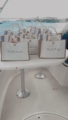 bags with name tags on them are sitting on the back of a boat