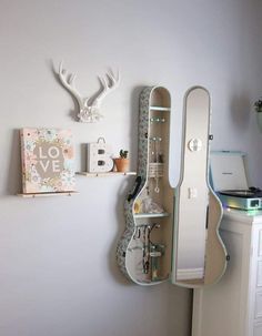 there is a guitar case hanging on the wall next to a shelf with various items