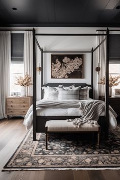 a bedroom with a four poster bed and white curtains