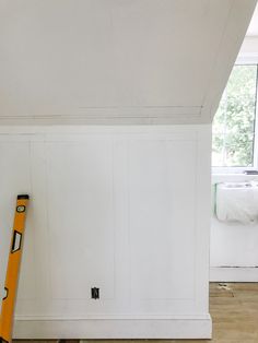 a ladder leaning against the wall in a room with white walls and wood flooring