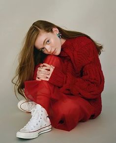 a woman sitting on the ground with her legs crossed