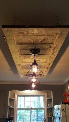 a kitchen with an old light fixture hanging from the ceiling and a window in the background