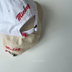 a baseball cap with the word mickey on it sitting on top of a white surface