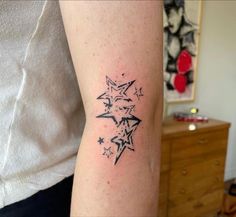 a person with a tattoo on their arm that has stars in the shape of a star