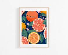 an orange and grapefruit print hangs on a white wall in front of a blue background