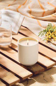 a white candle sitting on top of a wooden table