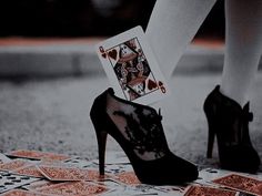 a woman's legs and heels with playing cards on them