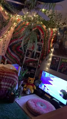 a living room filled with lots of plants and decorations on the wall above a flat screen tv