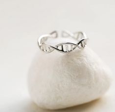 a silver ring sitting on top of a rock