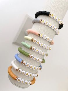 one heishi beaded name bracelet bracelets are made on a durable stretch elastic cord please refer to our sizing guide before purchasing Clay Bead Bracelet Ideas With Names, Adjustable Stacked Beaded Bracelets For Everyday, Trendy Stretch Bracelet With Letter And Heishi Beads, Everyday Stacked Stretch Bracelet With Round Beads, Adjustable Stacked Stretch Bracelet For Friendship, Personalized Heishi Beads Stretch Bracelet For Friendship, Trendy Personalized Heishi Beads Stretch Bracelet, Personalized Trendy Heishi Beads Stretch Bracelet, Personalized Casual Stretch Bracelet For Everyday