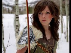 a woman holding a pole in the snow with her hand on it's shoulder