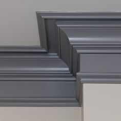 the corner of a room with gray paint and molding on it's walls