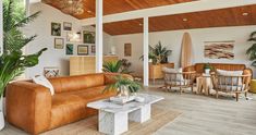 a living room filled with furniture and plants