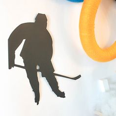 a paper cutout of a hockey player with a yellow hoop on the wall next to it