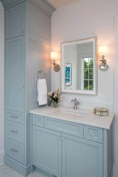 a bathroom with blue cabinets and white counter tops