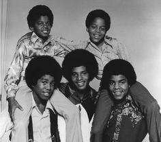 an old black and white photo of the jacksons posing for a group shot in front of a wall