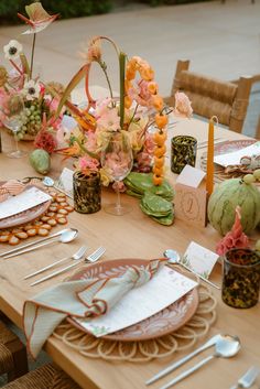 the table is set with flowers and place settings